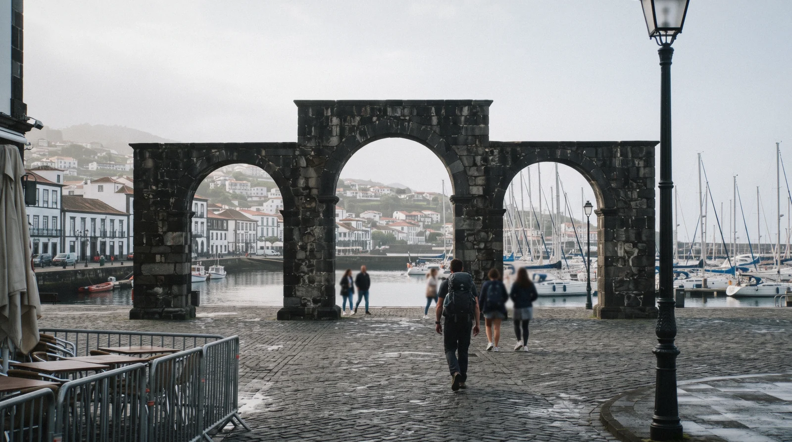 The Portas da Cidade gates and the marina front of Ponta Delgada on São Miguel, with cobblestone streets and the harbour beyond