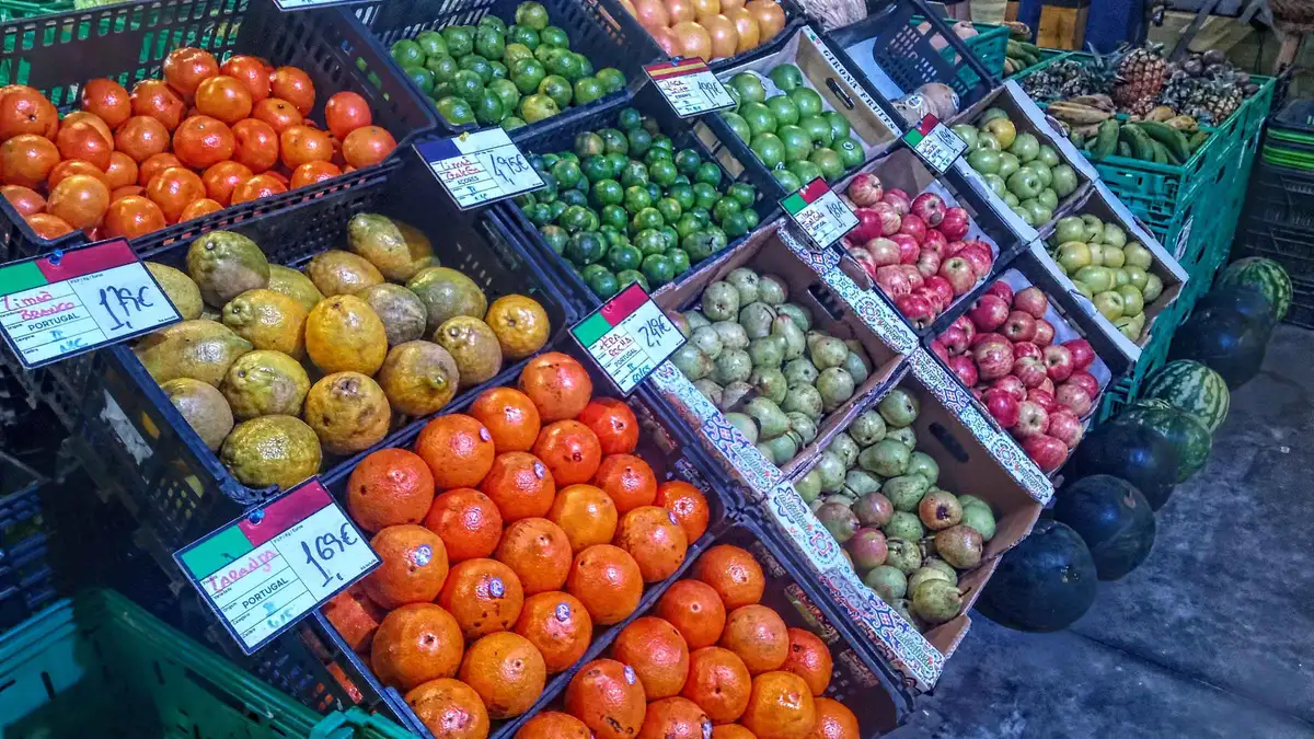 Crates of oranges, passion fruit and apples at a Ponta Delgada market on a small-group food tour with restaurant stops
