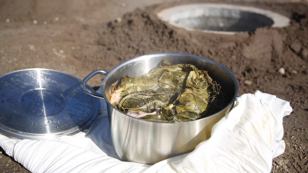 A steel pot of cozido lifted steaming from the volcanic cooking pit, the signature Azores food ritual of Furnas