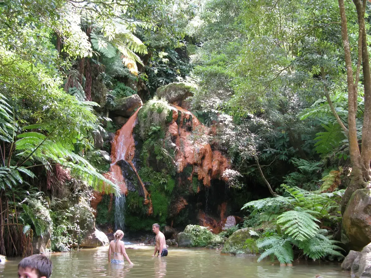 The iron-stained waterfall and bathing pool of Caldeira Velha under tree ferns, São Miguel