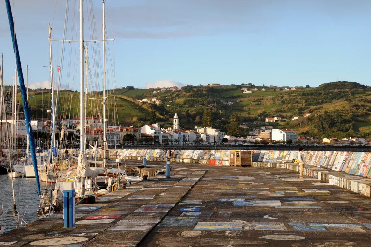 Yacht masts and the painted breakwater of Horta marina on Faial island in the Azores